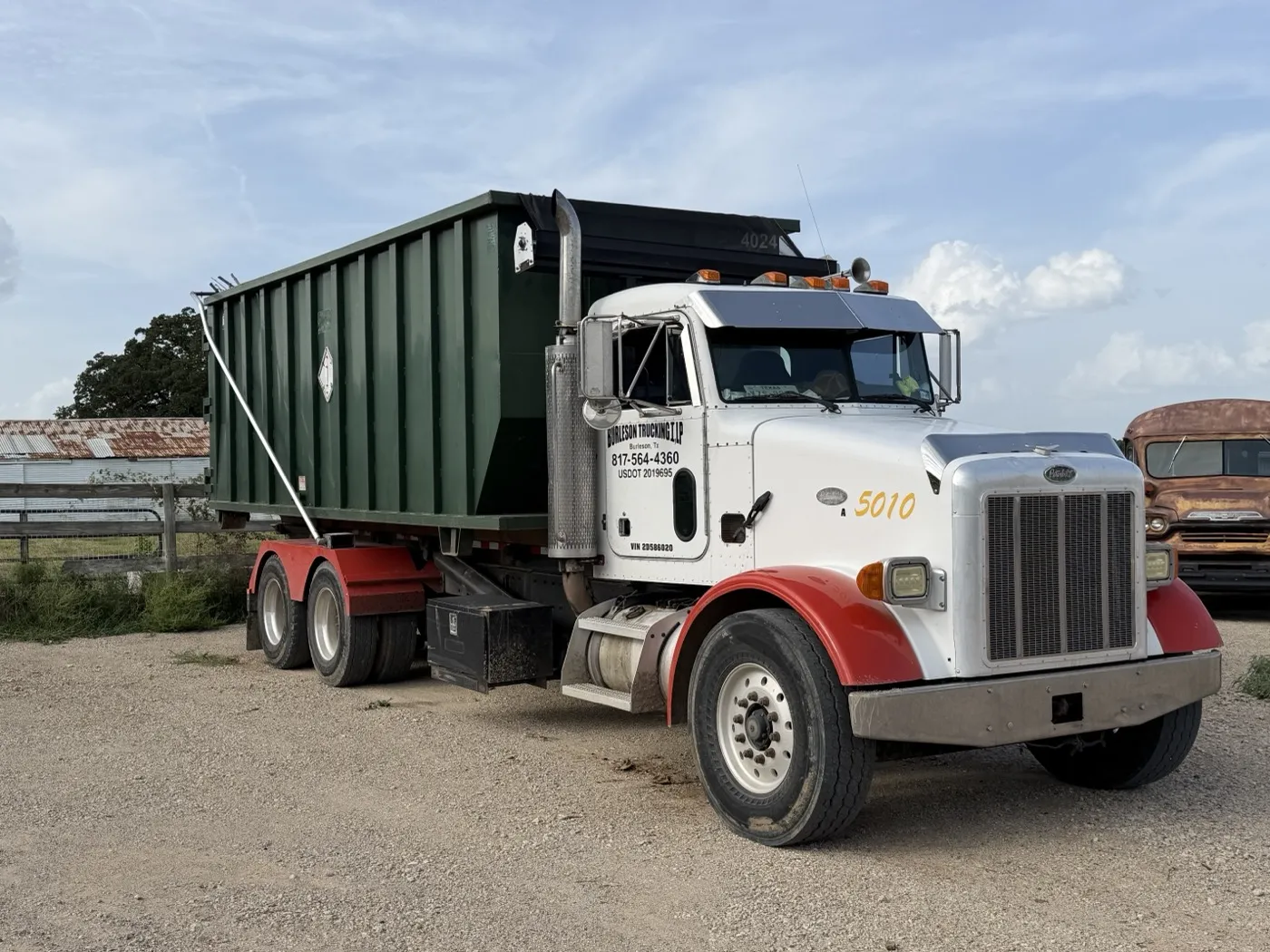 Texas Best roll-off truck carrying a dumpster at the Burleson yard